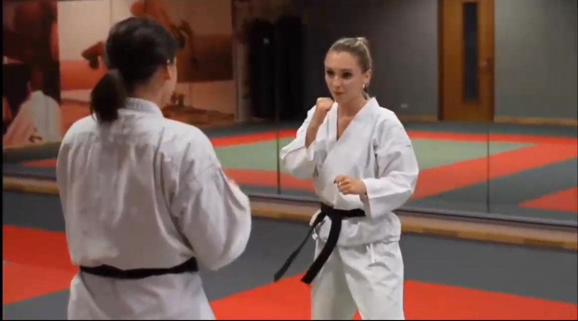 Fight of 2 barefoot black belts in dojo 